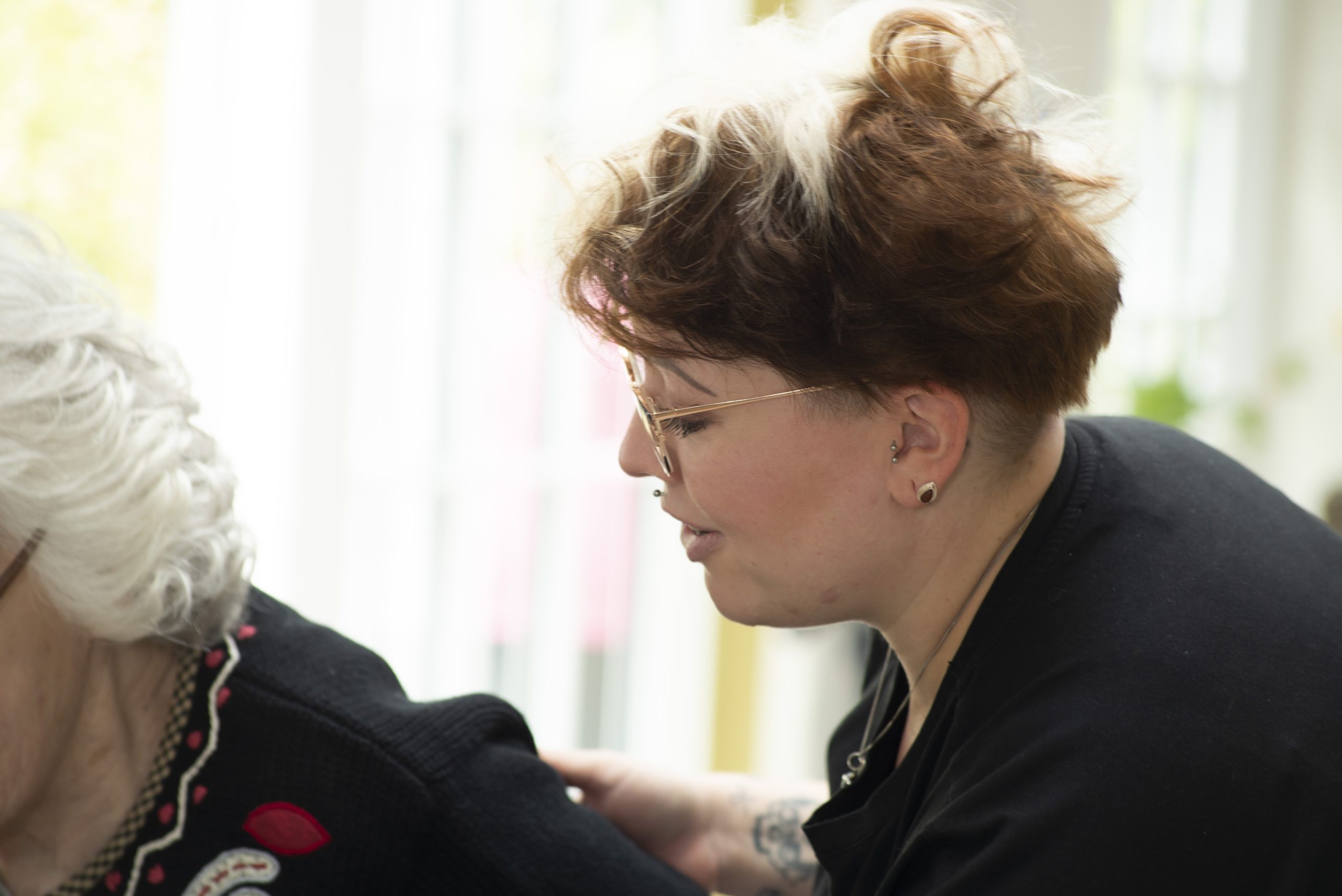 Care staff supporting a resident living with dementia at Elliscombe House care home in Somerset.